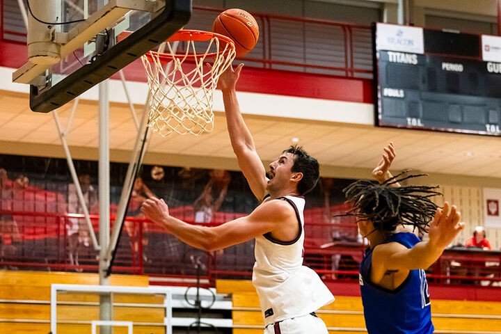 A men's basketball player drives in for a layup.